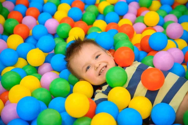 Birçok küçük renkli topları ile oyun odasında bir çocuk