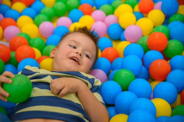 Birçok küçük renkli topları ile oyun odasında bir çocuk