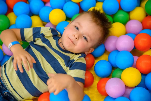 Birçok küçük renkli topları ile oyun odasında bir çocuk