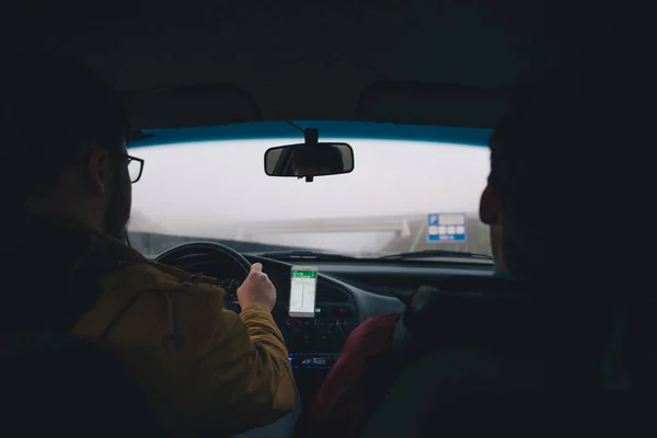 Dos hombres conduciendo por autopista con navegación en el teléfono — Foto de Stock