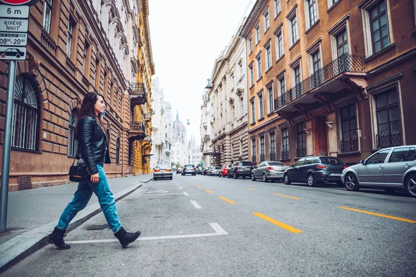 女性は、古いヨーロッパの都市で道路を横断します。 — ストック写真