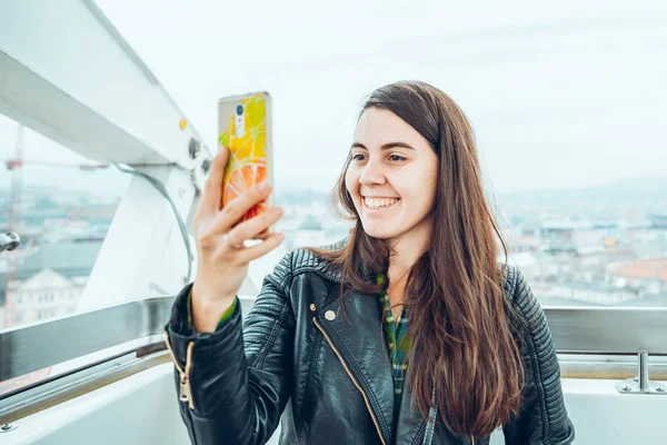 Menina bonita tirando foto na roda gigante em seu telefone — Fotografia de Stock