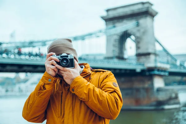 Young man photographer shooting old bridge on background — Stock Photo, Image