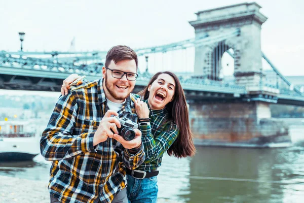 Śliczny cople biorąc zdjęcie mostu na tle — Zdjęcie stockowe