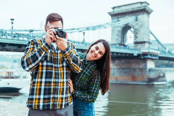 Lovely cople taking picture bridge on background — Stockfoto