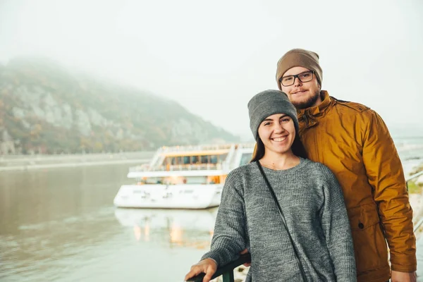 Couple debout près de bateau de rivière avec montagne sur terrain vague — Photo