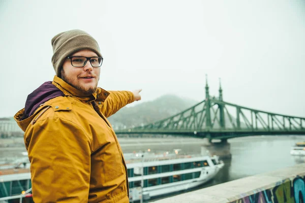 Человек, указывающий, стоя у реки в туманное утро — стоковое фото