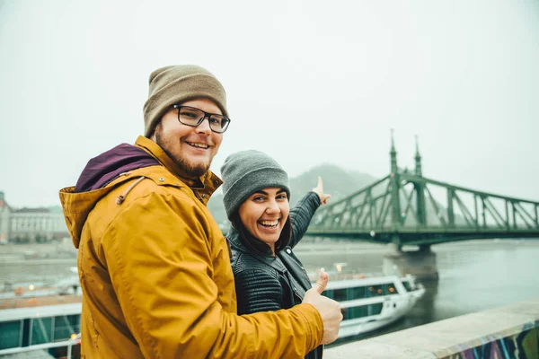 Uomo indicando mentre in piedi vicino al fiume nella nebbia mattina — Foto Stock