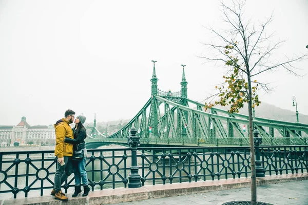 Cuplu sărutându-se lângă podul vechi dimineața — Fotografie, imagine de stoc