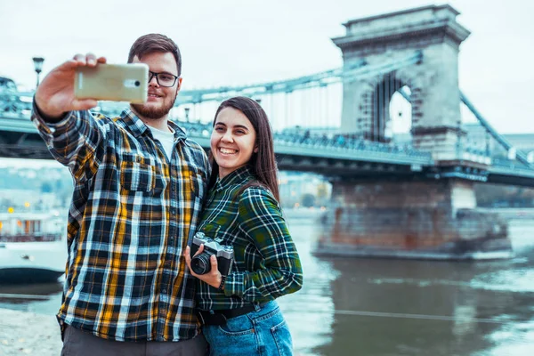 Mooie cople nemen selfie brug op de achtergrond — Stockfoto