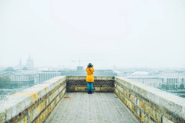 Женщина стоит на краю с красивым городским пейзажем — стоковое фото