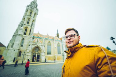 adam arka plan üzerinde eski kilise ile selfie alarak