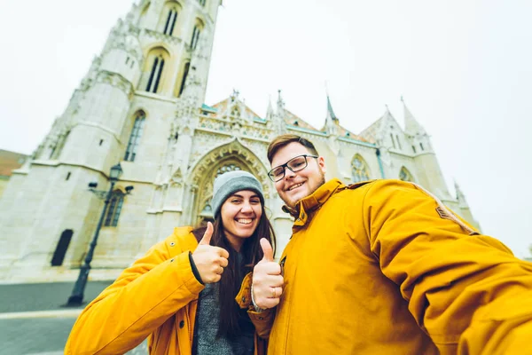 Couple making selfie against church
