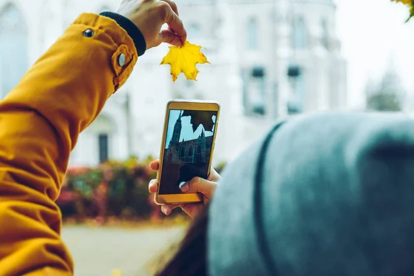 Woman taking picture on her phone of old church — Stock Photo, Image