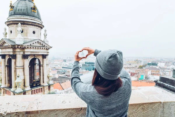 Donna mostra il cuore con le mani con bella vista della vecchia città europea su sfondo — Foto Stock