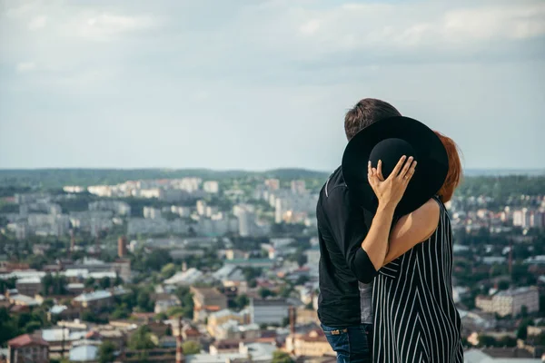 Mujer beso novio mientras oculto detrás de el sombrero —  Fotos de Stock