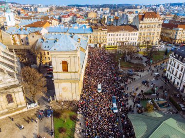 LVIV, UKRAINE - APRIL 6, 2018: Procession with a large cross. The crowd is walking their temple to the temple clipart