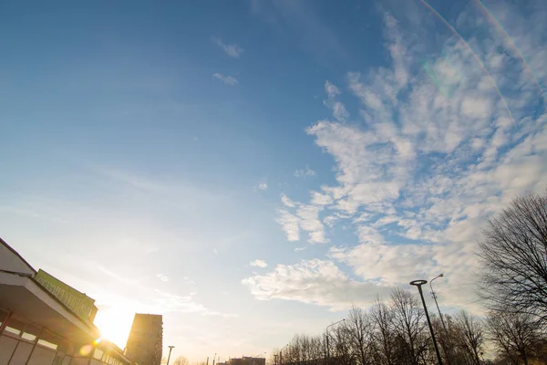Puesta de sol con cielo azul y nubes blancas. vista a la calle —  Fotos de Stock