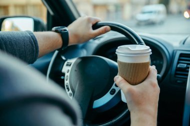 adam eller direksiyon simidi ve kahve fincan tutarak. sabah Booster