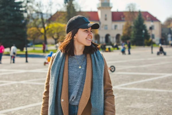 Giovane bella donna alla moda che cammina in cappotto marrone per strada — Foto Stock