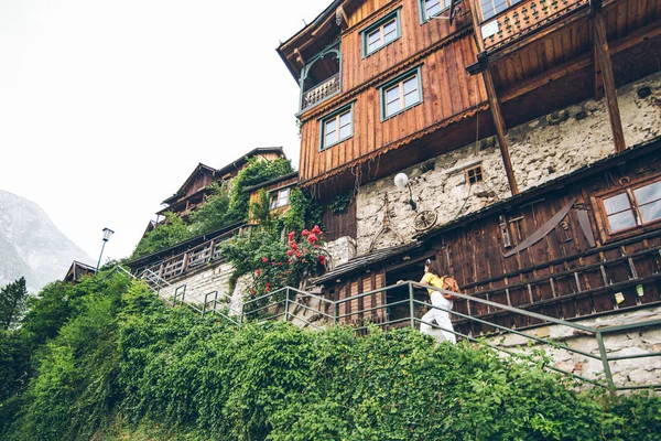 Young pretty smiling tourist woman walking by small hallstatt street stairs — Stock Photo, Image