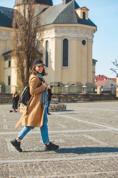 Mladá hezká módní žena kráčející v hnědém kabátu po ulici — Stock fotografie