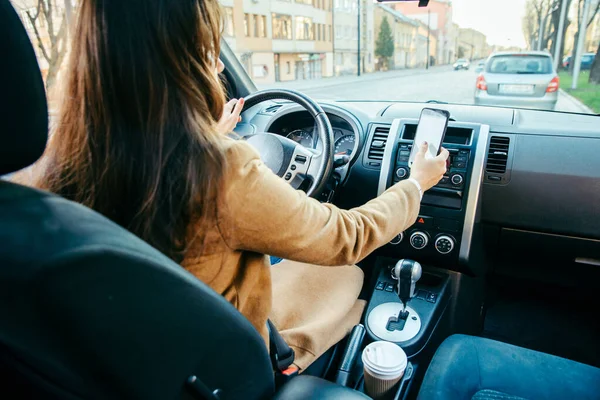 Ung kvinna kör bil och använder telefonen som navigering — Stockfoto