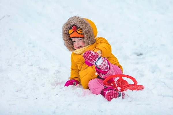 Klein kind op slee glijden door de winter heuvel — Stockfoto