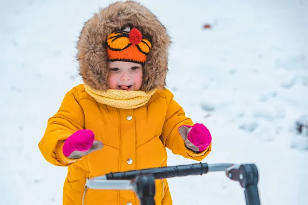 Klein meisje met slee op sneeuwde winterdag — Stockfoto