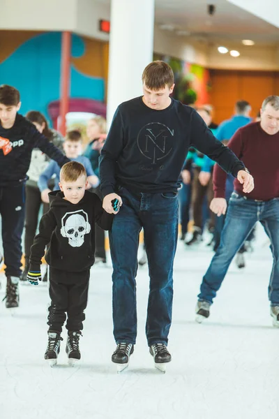 Lviv, Ukraine - 3. Februar 2019: Vater bringt Sohn das Schlittschuhlaufen auf der Eisbahn bei — Stockfoto