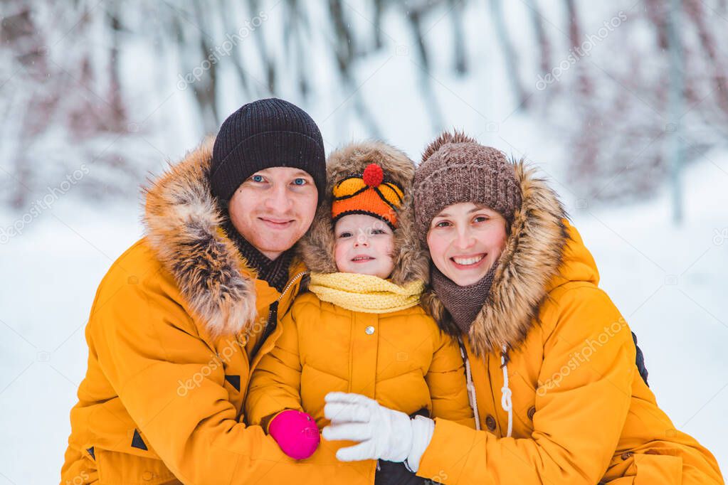 portrait of young family at yellow winter coats