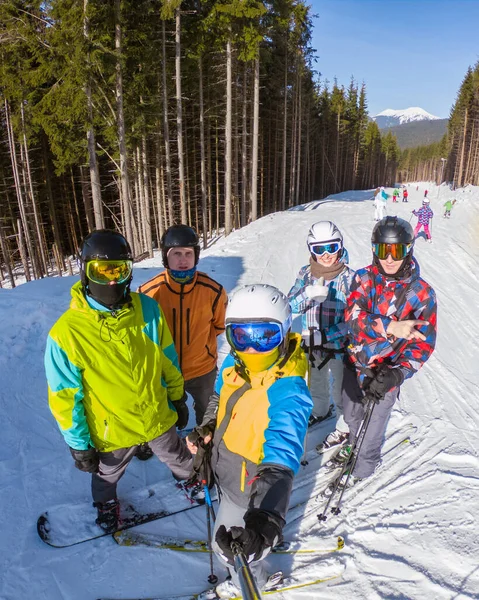 Grupo de pessoas com snowboards e esquis tomando selfie no topo da colina — Fotografia de Stock