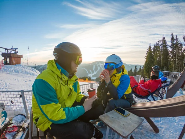 Casal descansando no topo da colina bebendo chá de aquecimento. snowboard esqui — Fotografia de Stock