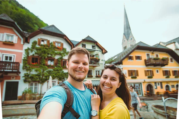 Sourire beau couple prendre selfie à hallstatt ville place centrale — Photo