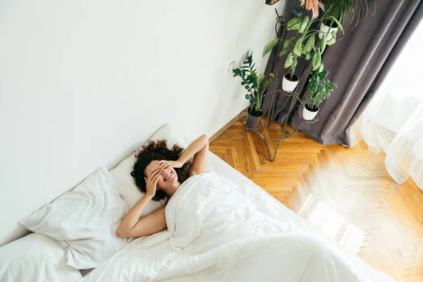 Ung vacker kvinna i sängen med vita lakan ljust ljus — Stockfoto