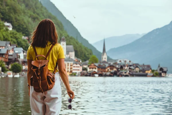 Kadın hallstatt şehir bakarak sahilde ayakta — Stok fotoğraf