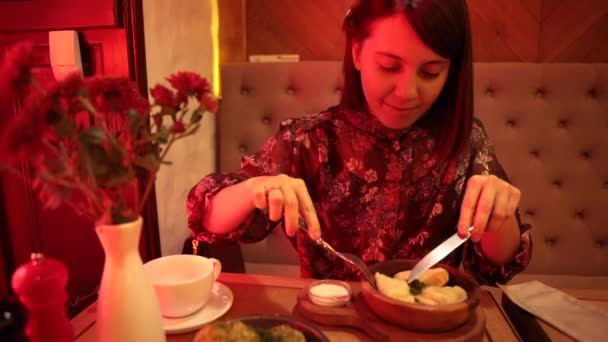 Mujer comiendo albóndigas en la cafetería con luz roja — Vídeos de Stock