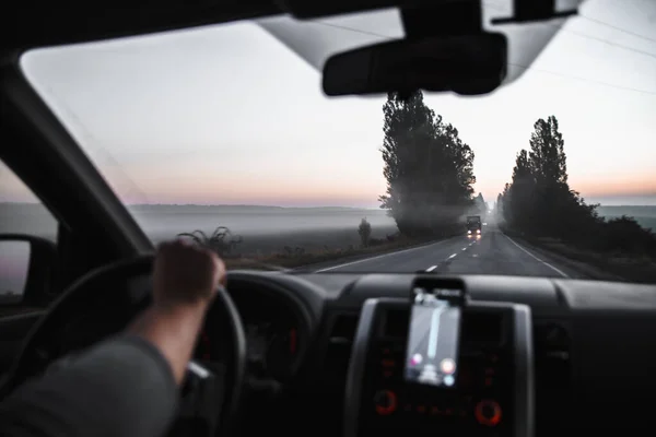 Auto concetto di viaggio mani sulla strada sterzante in nebbia — Foto Stock