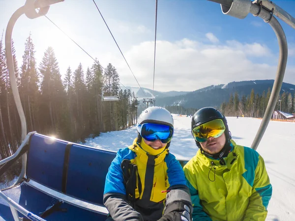 Pareja tomando selfie en equipo de esquí mientras levantan hasta la colina —  Fotos de Stock