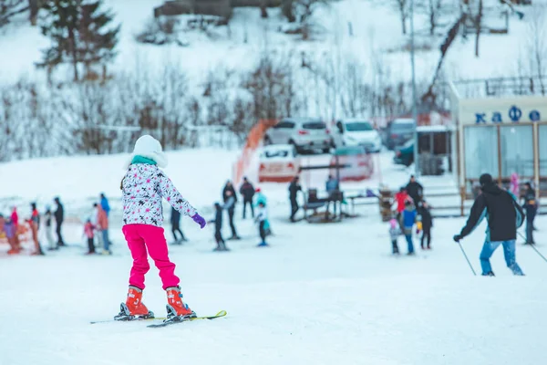 LVIV, UCRANIA - 12 de enero de 2019: niña en pantalones rosas esquiando por una colina nevada — Foto de Stock