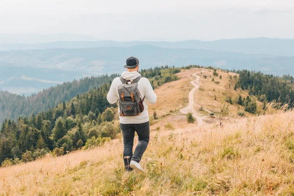 Man med ryggsäck vandring genom höst berg — Stockfoto