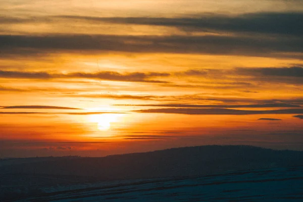 Sonnenuntergang über dem verschneiten Winterfeld — Stockfoto