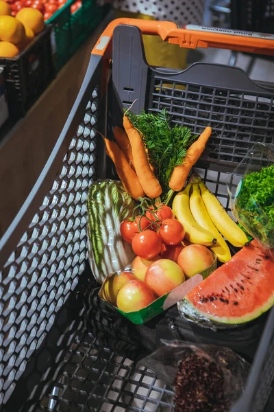 Vista del carrito de la compra lleno de verduras y frutas — Foto de Stock
