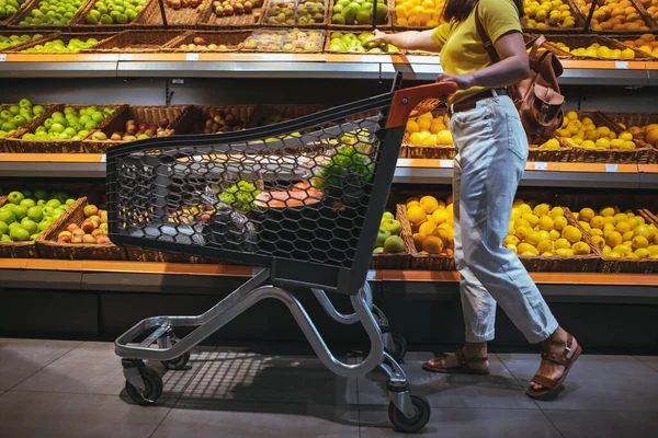 Frau mit Einkaufswagen auf Lebensmittelmarkt — Stockfoto