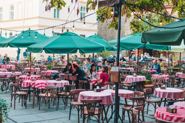 Lviv, Ucrania - 5 de septiembre de 2019: las personas que comen hablando beben en el restaurante cafetería al aire libre — Foto de Stock