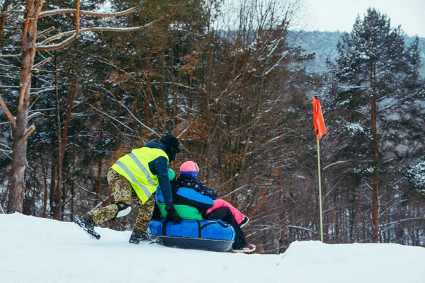 Atividades divertidas de inverno. passeio para baixo pela colina na tubulação de neve — Fotografia de Stock
