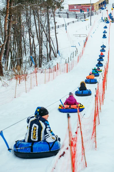 Lviv, ukraine - 7. januar 2019: linie für snow tubing. Menschen auf Hügel ziehen. — Stockfoto