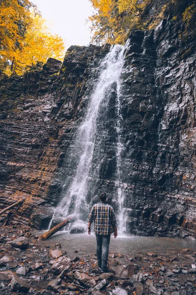 Caminhante homem olhando para cachoeira outono — Fotografia de Stock