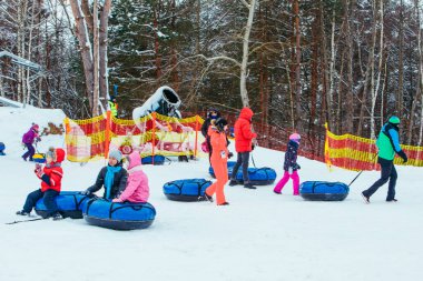 Lviv, Ukrayna - 7 Ocak 2019: Aile gezisi kar tübü ile kar tepesinde