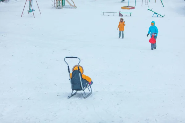 Маленька дитина на санчатах ковзає до зимового пагорба — стокове фото
